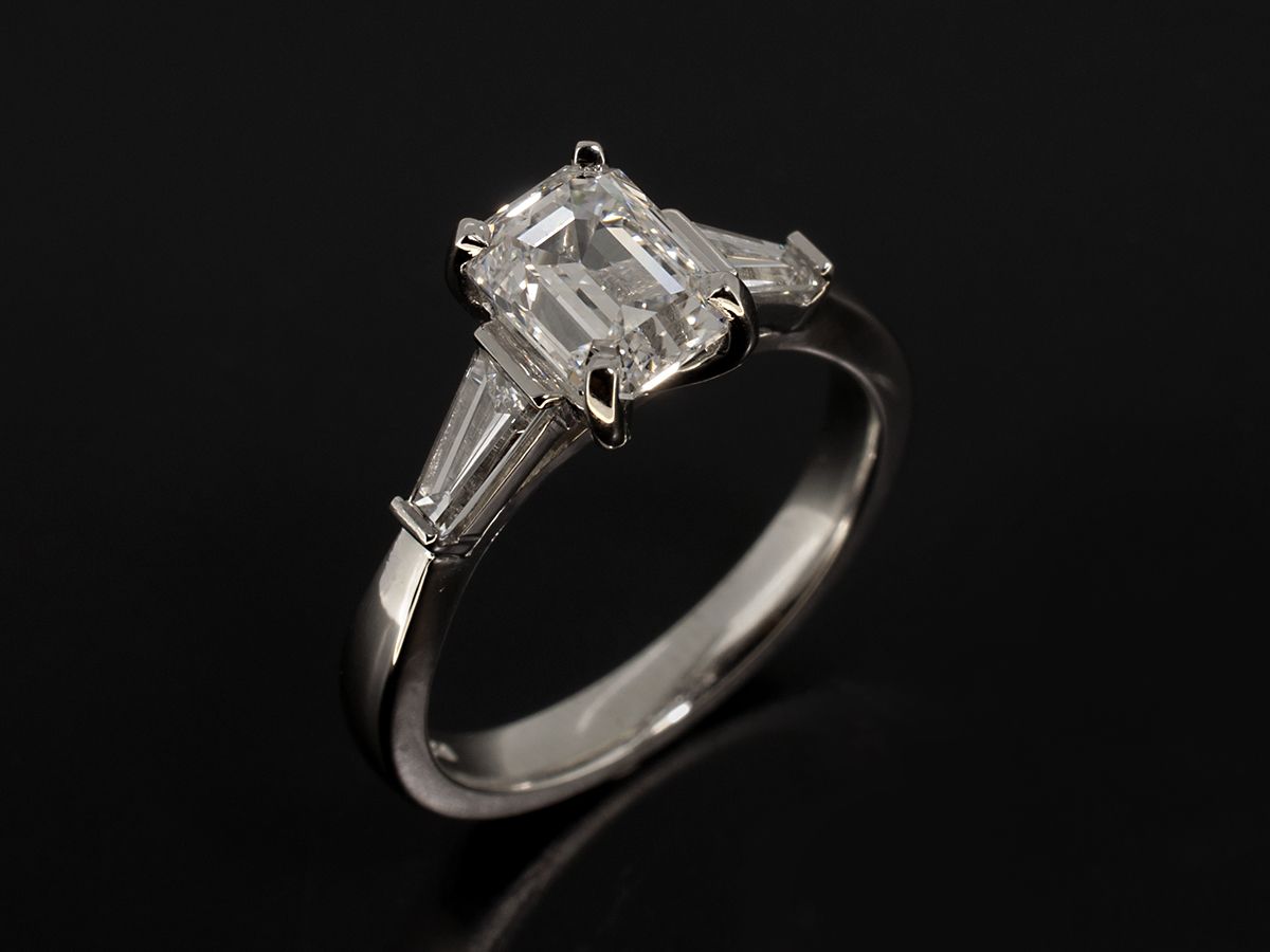 Emerald cut 1.51ct with tapered side stones, in platinum.